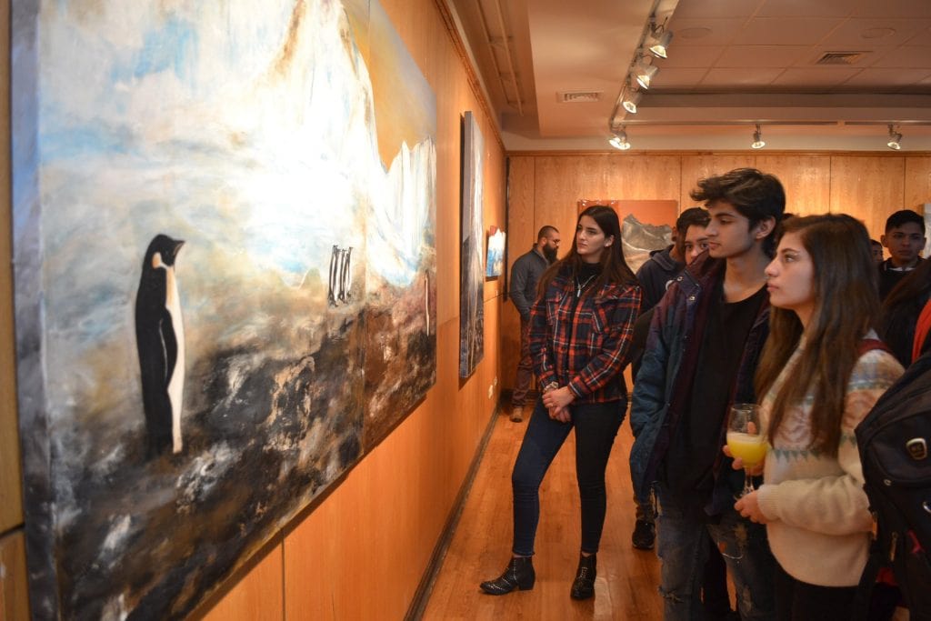 Grupo de personas observando obra de arte en sala
