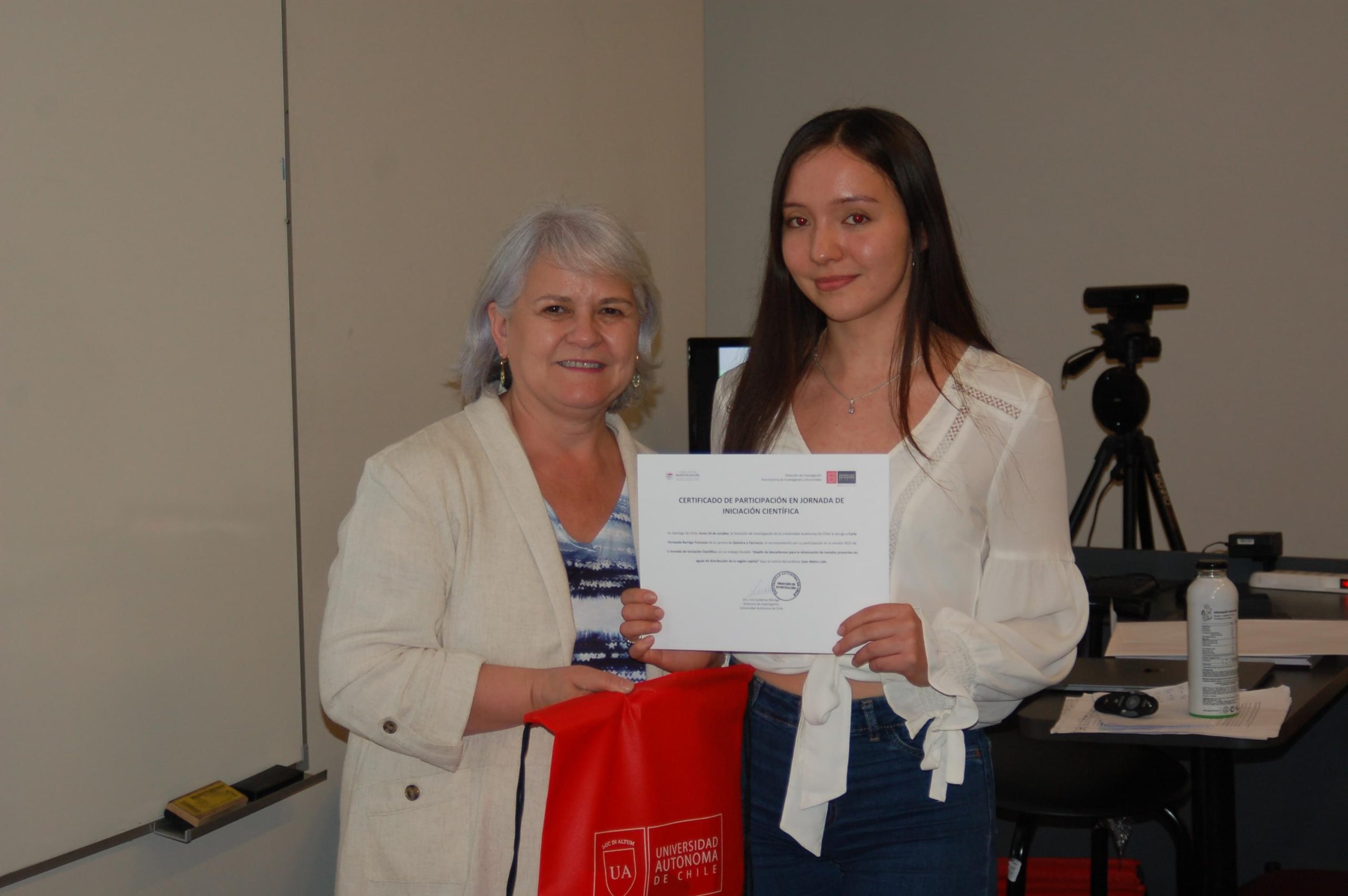 dos mujeres sosteniendo un certificado