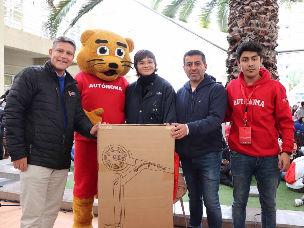 Ganadora del scooter eléctrico con autoridades de la Universidad en el Campus El Llano Subercaseaux