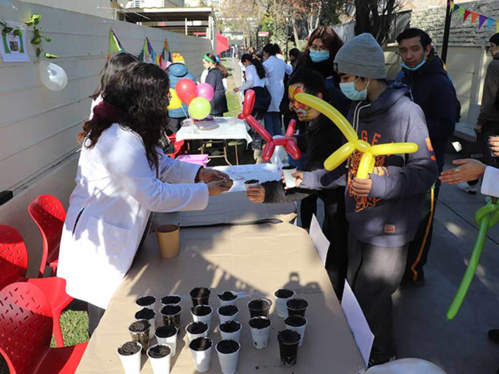 Alumno de la Escuela Los Cedros interactuando con estudiante de la Universidad Autónoma