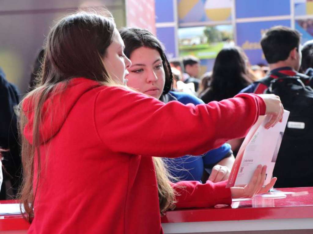 Estudiante de cuarto medio recibiendo información en el stand de la Universidad Autónoma