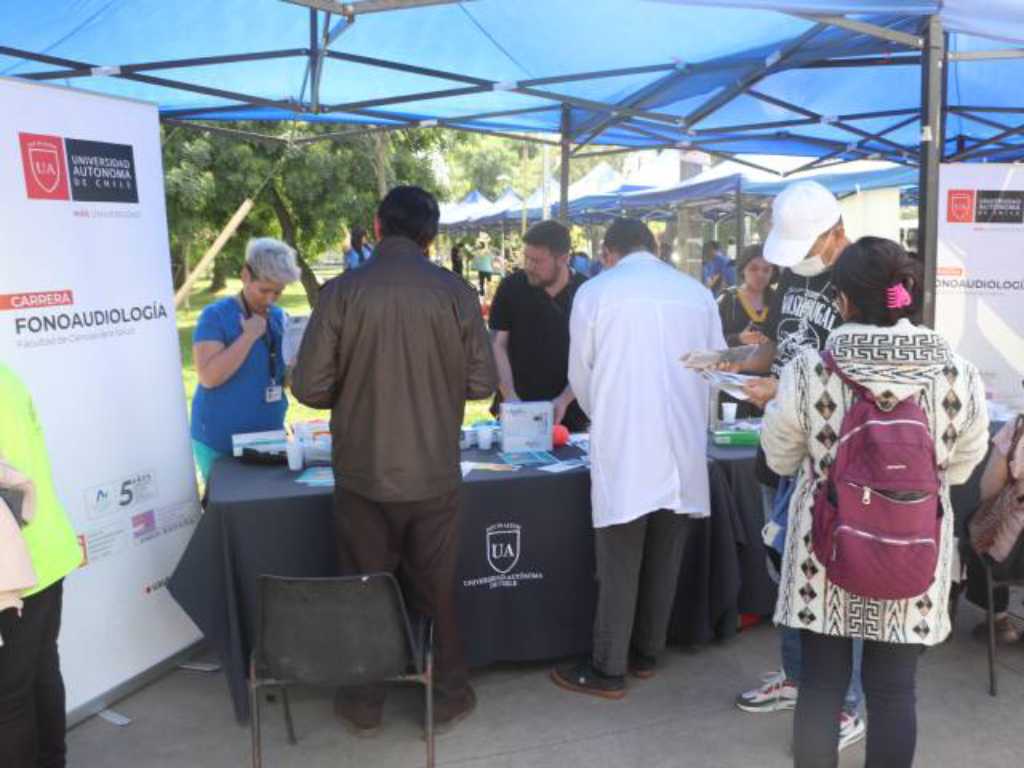 Estudiantes y docentes de Fonoaudiología recibiendo a los vecinos de San Miguel en su stand en la feria