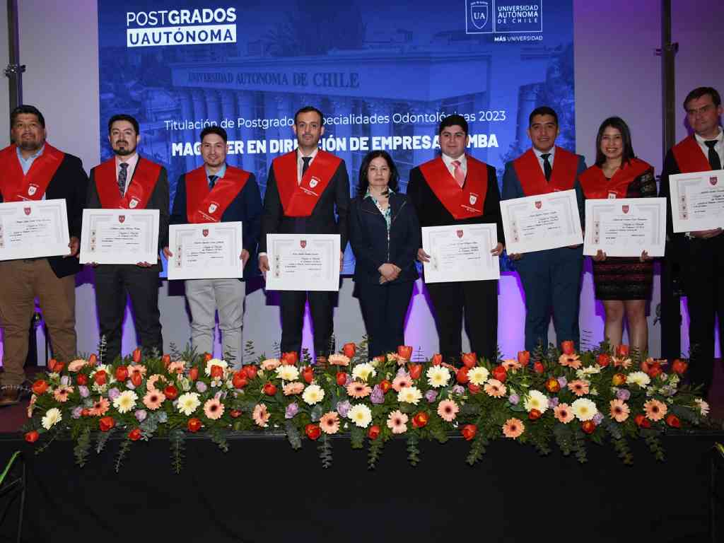 Grupo de titulados posando junto a sus diplomas
