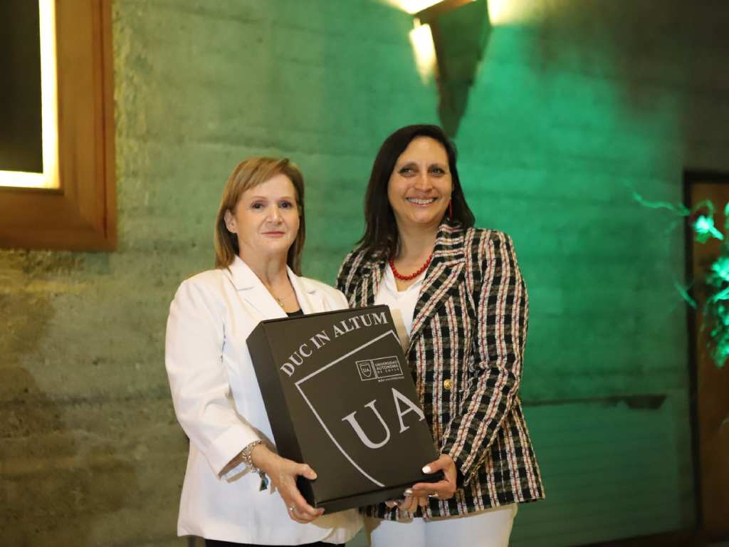 Olga Muñoz recibiendo un reconocimiento de la Universidad Autónoma