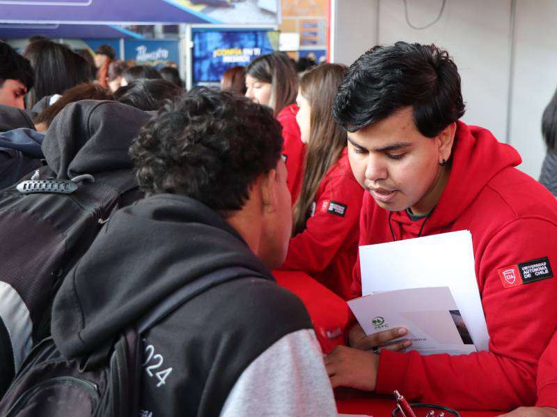 Monitores del stand de la Universidad Autónoma entregándole información a los estudiantes de la feria