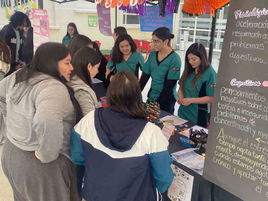 Estudiantes de terapia ocupacional recibiendo visitantes en su stand