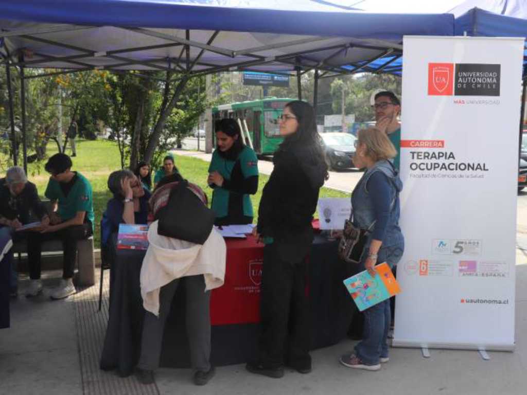 Estudiantes de Terapia Ocupacional recibiendo a vecinas en su stand 