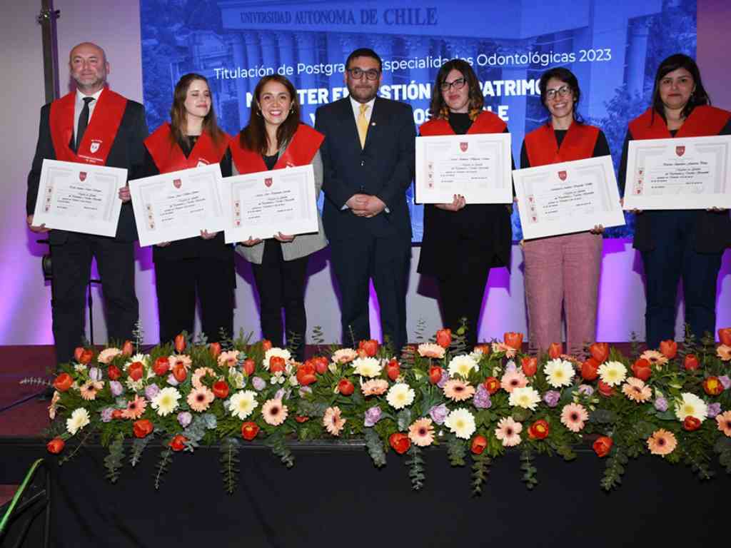 Titulados del magíster sosteniendo sus diplomas