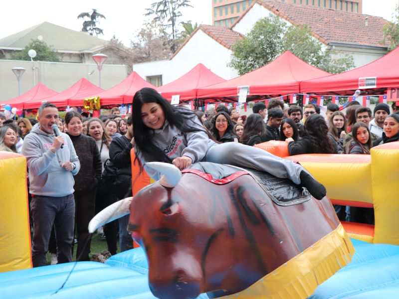 Estudiante del Campus Providencia arriba del toro mecánico