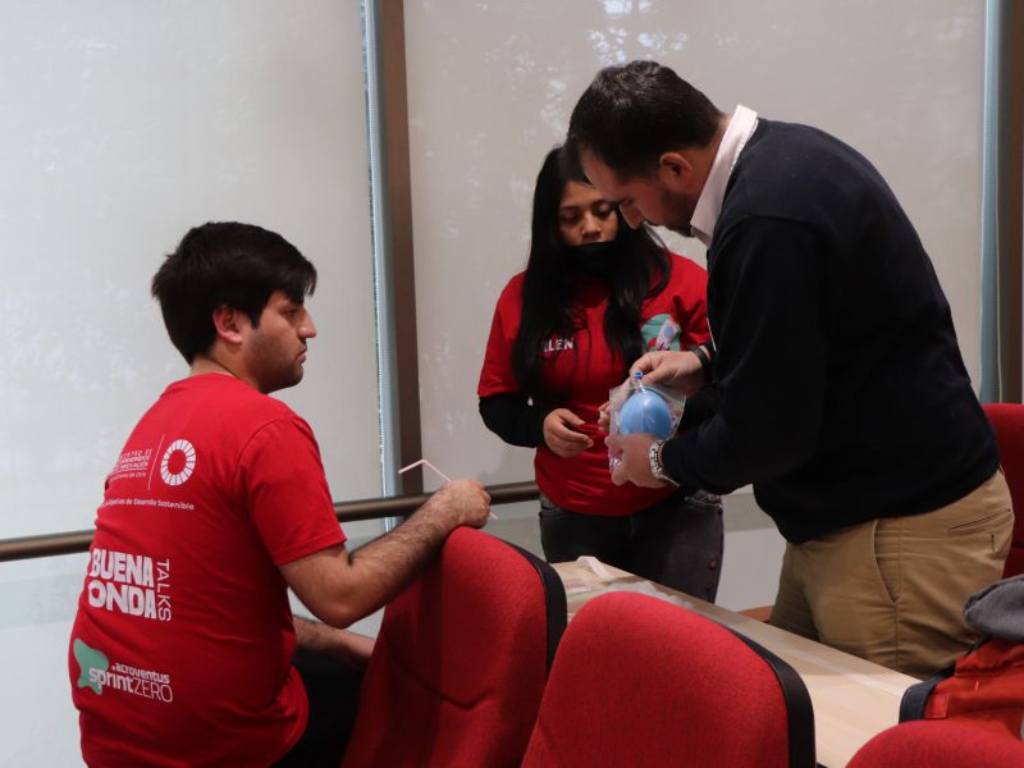 Estudiantes participantes de las Buena Onda Talks, armando un proyecto junto a un docente