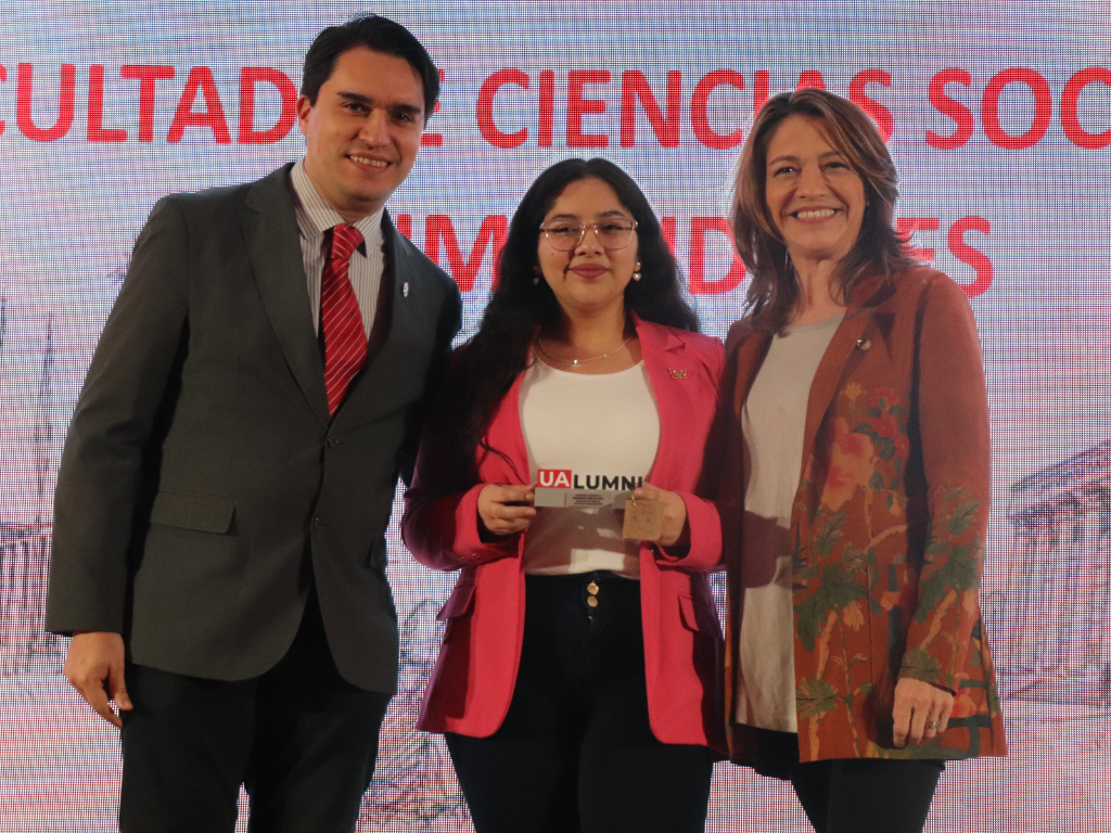 Egresada recibiendo reconocimiento.